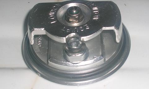 [The underside of the gas cap with the ground-down locking pin.]